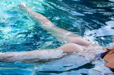 Девушка с красивой жопой купается голая в бассейне