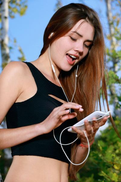 Русская ню модель стоит голая в лесу возле березы