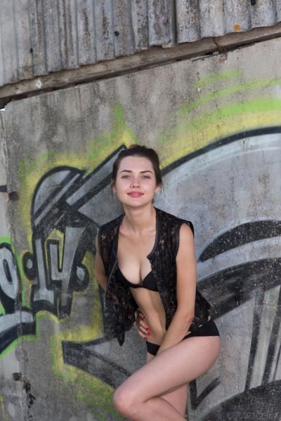 Красотка разделась на улице возле стены с граффити